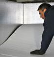 contractor installing TerraBlock™ floor insulation in a Vineland crawl space