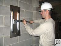 Attempting to straighten a bowed foundation wall by straightening a wall anchor system in a Vineland home.