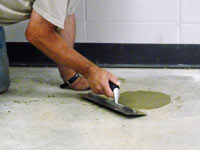 Repairing the cored holes in the concrete slab floor with fresh concrete and cleaning up the Vineland home.