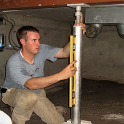 A contractor in Norristown installing a crawl space jack post.