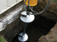 Installing a helical pier system in the earth around a foundation in Trenton