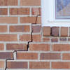 long jagged cracks starting at the corner of a window along a brick wall on a New Castle home