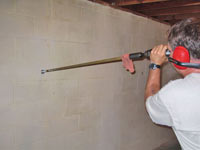 Drilling the hole in the foundation wall for street creep repairs in Trenton
