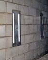 an inside view of foundation wall anchors installed along a basement wall to brace and repair the structure in Quakertown