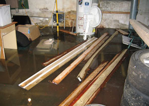 A severely flooding basement in Vineland, with lumber and personal items floating in a foot of water