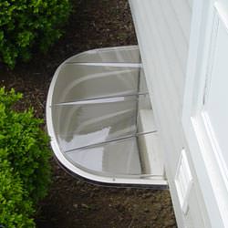 A vinyl basement window and covered window well in Cherry Hill